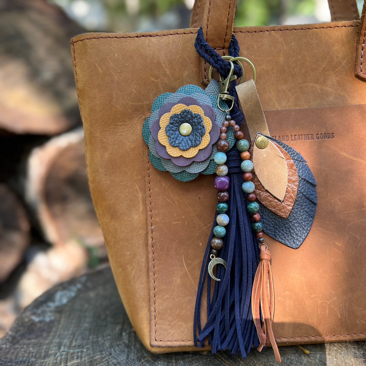 brown and blue leather bag charms with beaded and navy blue tassel on brown tote