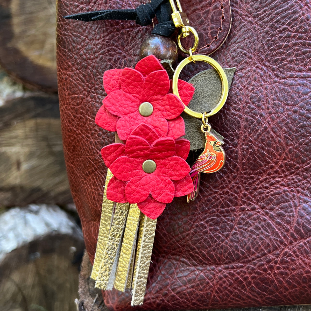 close up of red flower tassel charm and metal cardinal bag charm keychain