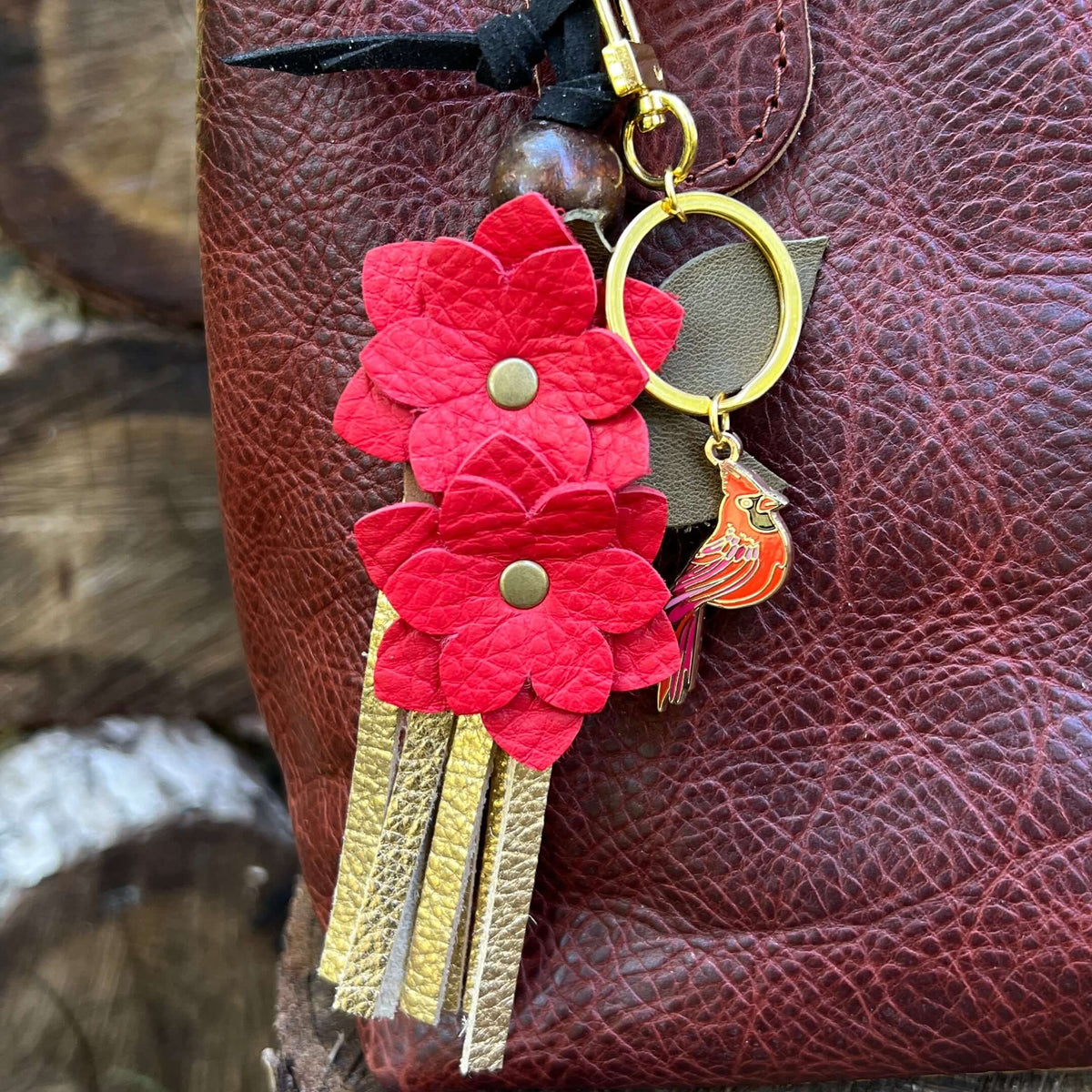 close up of red flower tassel charm and metal cardinal bag charm keychain