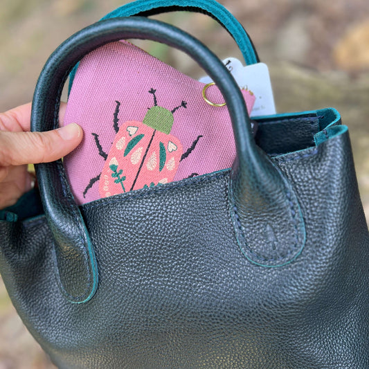dusty pink zipper pouch with embroidered beetle