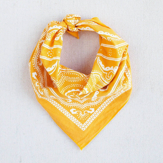 Yellow bandana with white patterns on a light gray background