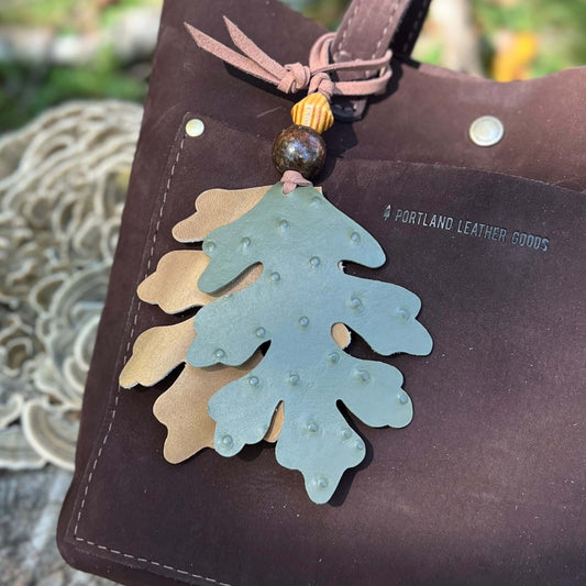 green and tan oak leaves with wooden beads leather bag charm on dark brown tote