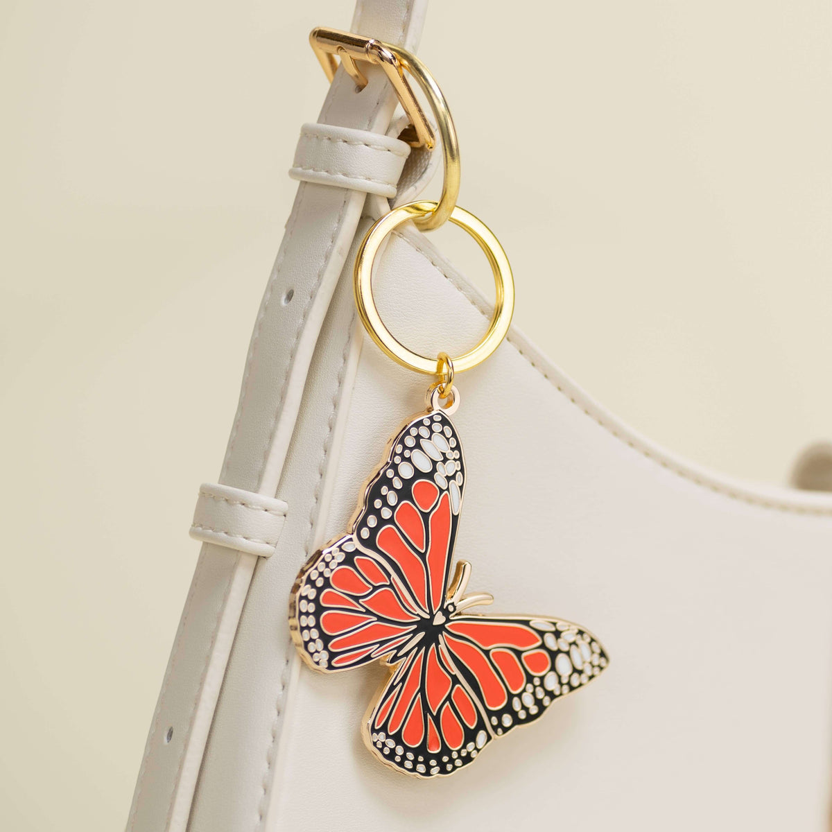 Butterfly-shaped keychain attached to a strap on a light background