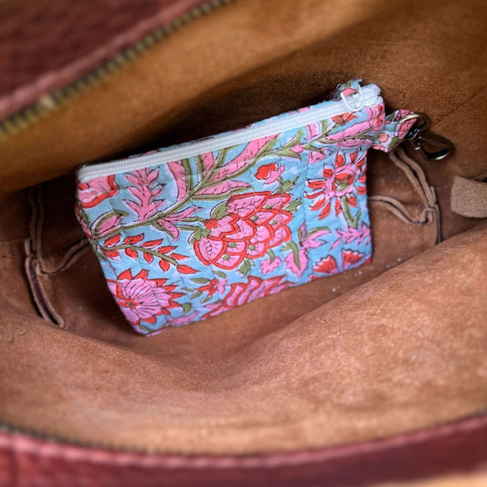 Floral-patterned pouch inside a brown leather bag