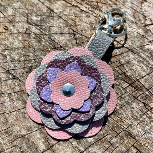 Floral-shaped keychain with pastel colors on a wooden surface