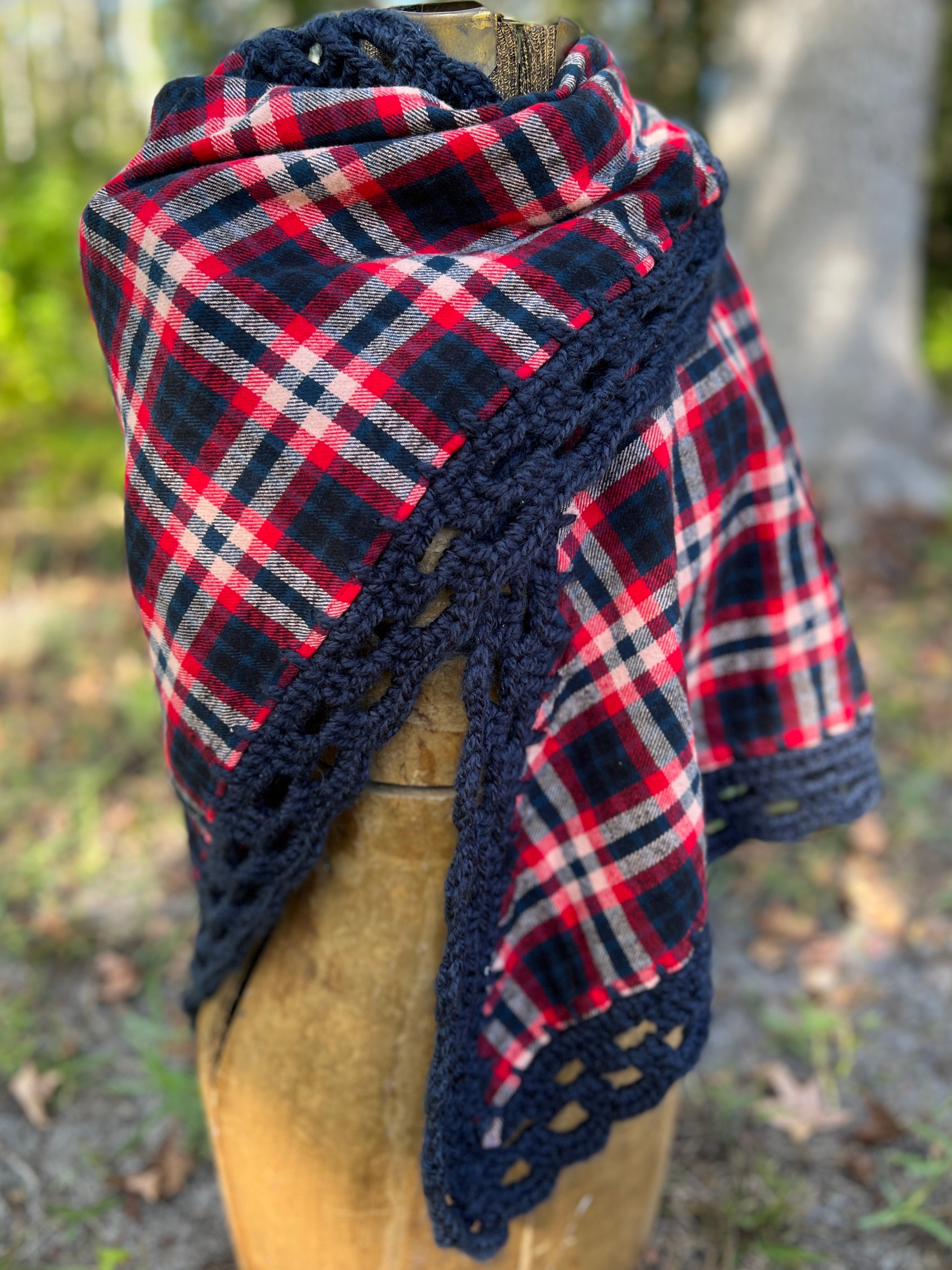 Plaid shawl with crochet border on a mannequin against a natural background