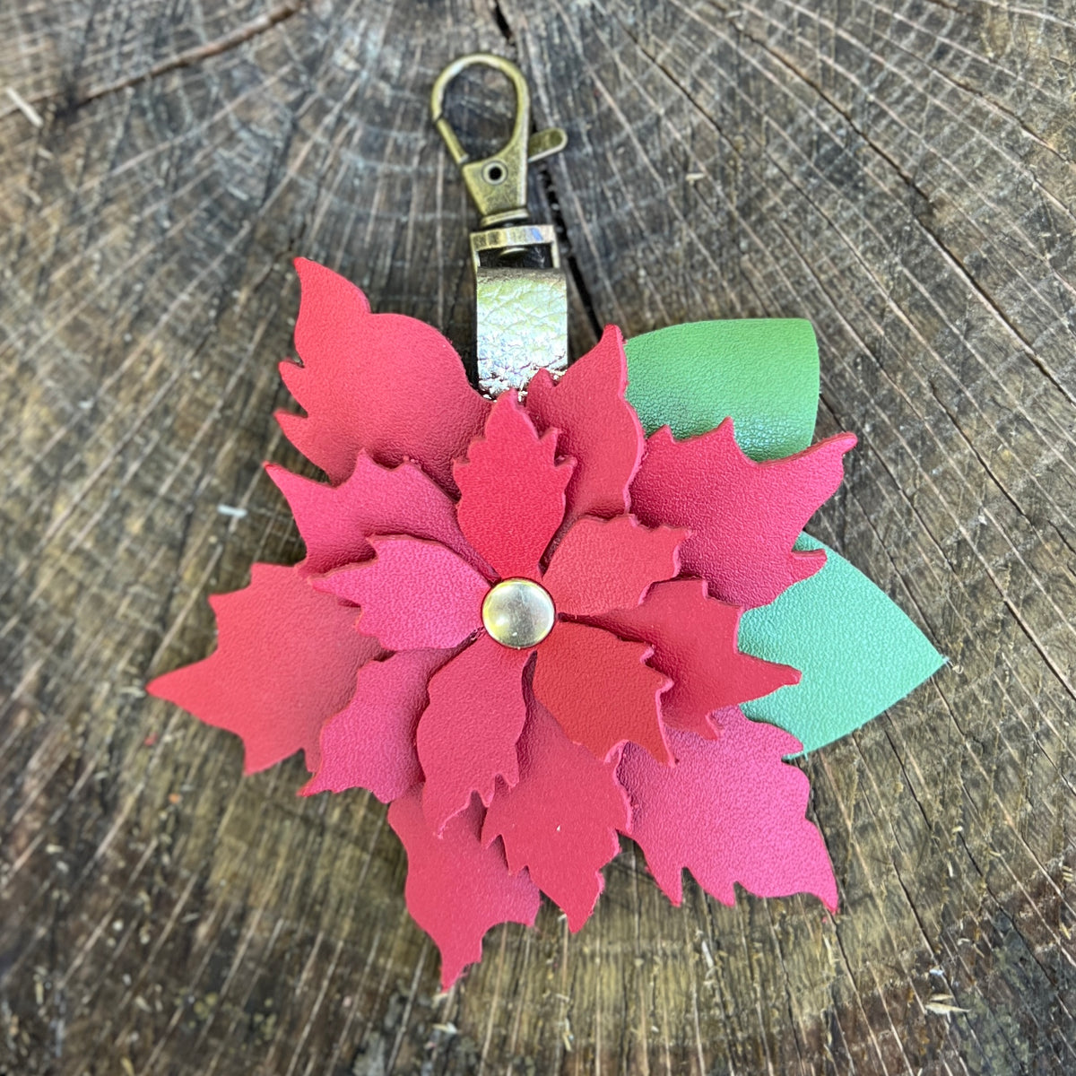 poinsettia flower bag charm on wood surface