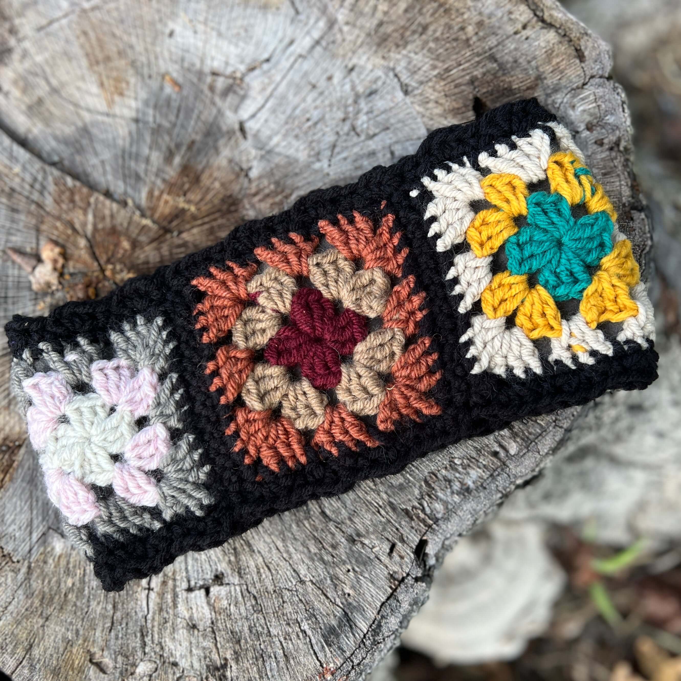 Crocheted headband with multicolor patterns on a wooden surface