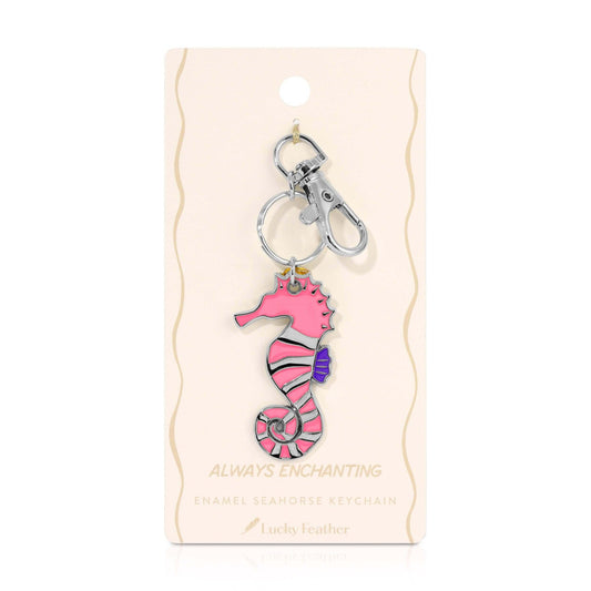 Pink seahorse keychain on a beige card with 'Always Enchanting' text