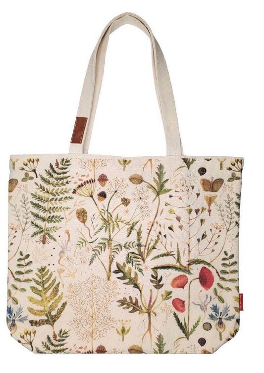 A canvas tote bag with a detailed botanical and wildflower print on a cream background, featuring natural beige shoulder straps and a small brown leather brand patch.