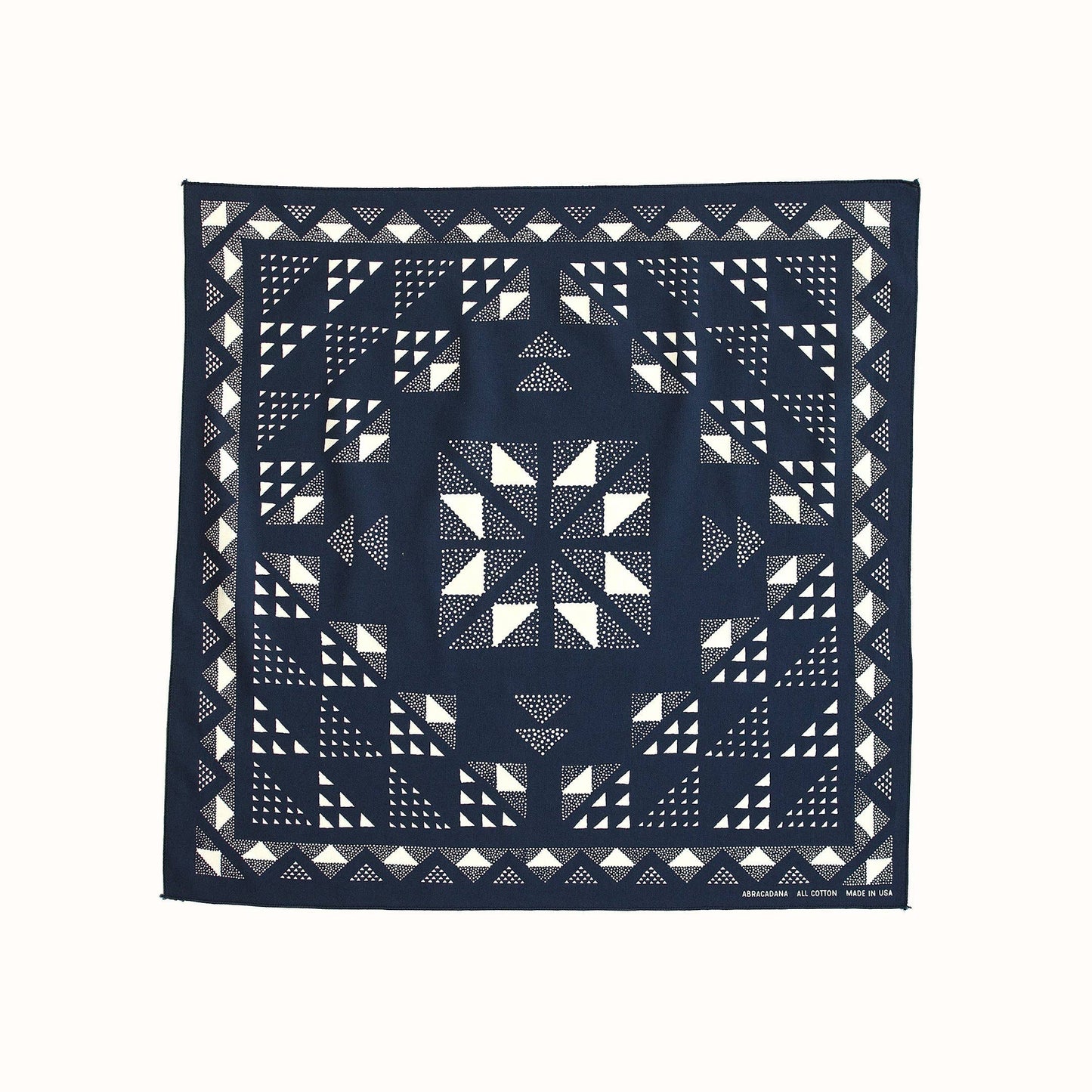 A square navy blue bandana featuring a white geometric quilted pattern, displayed flat against a solid off-white background.
