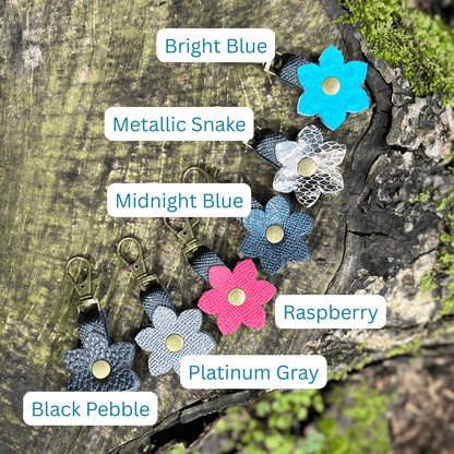 Flower-shaped keychains in various colors on a wooden surface