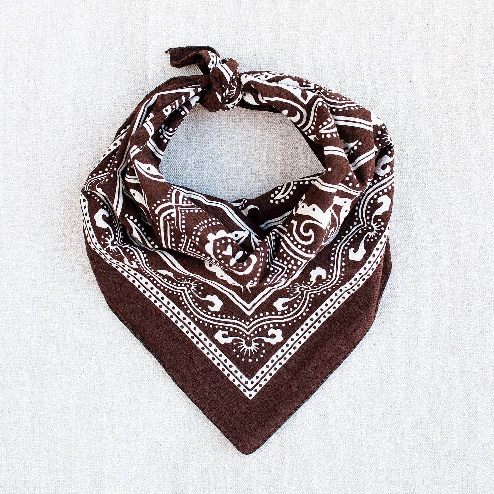 Brown bandana with white patterns on a light gray background
