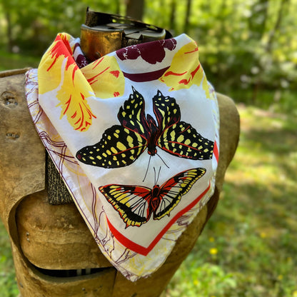 Butterfly-patterned bandana on a wooden post with a natural background