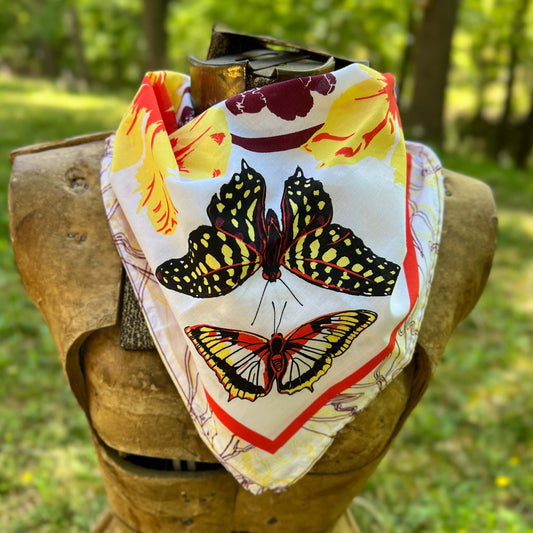 Butterfly patterned fabric draped over a wooden block with a natural outdoor background