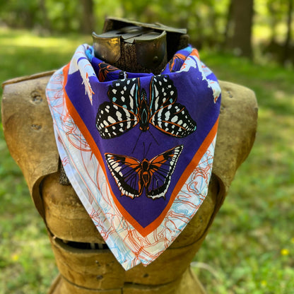 Butterfly patterned scarf on a mannequin head with a natural background