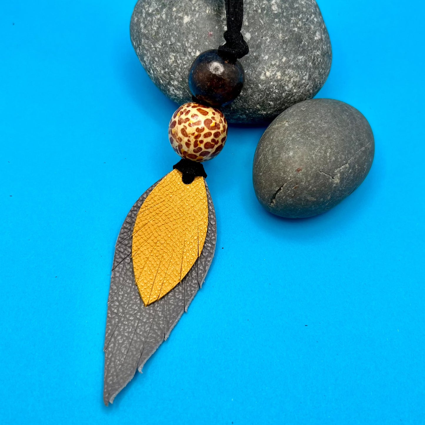 gray and yellow leather feather bag charm 