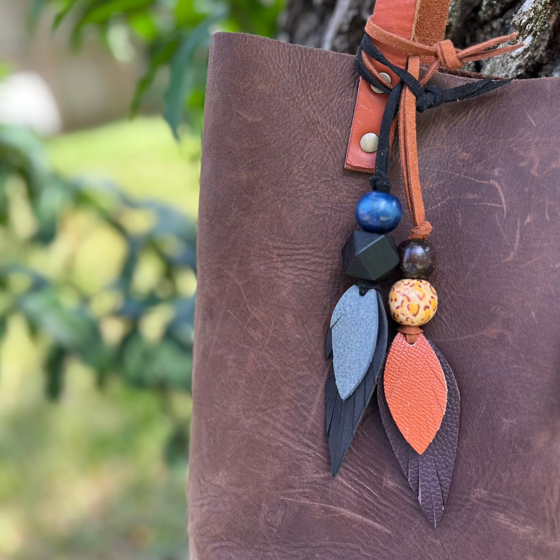 leather feather and wood bead purse charm