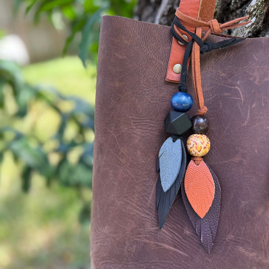 leather feather and wood bead purse charm