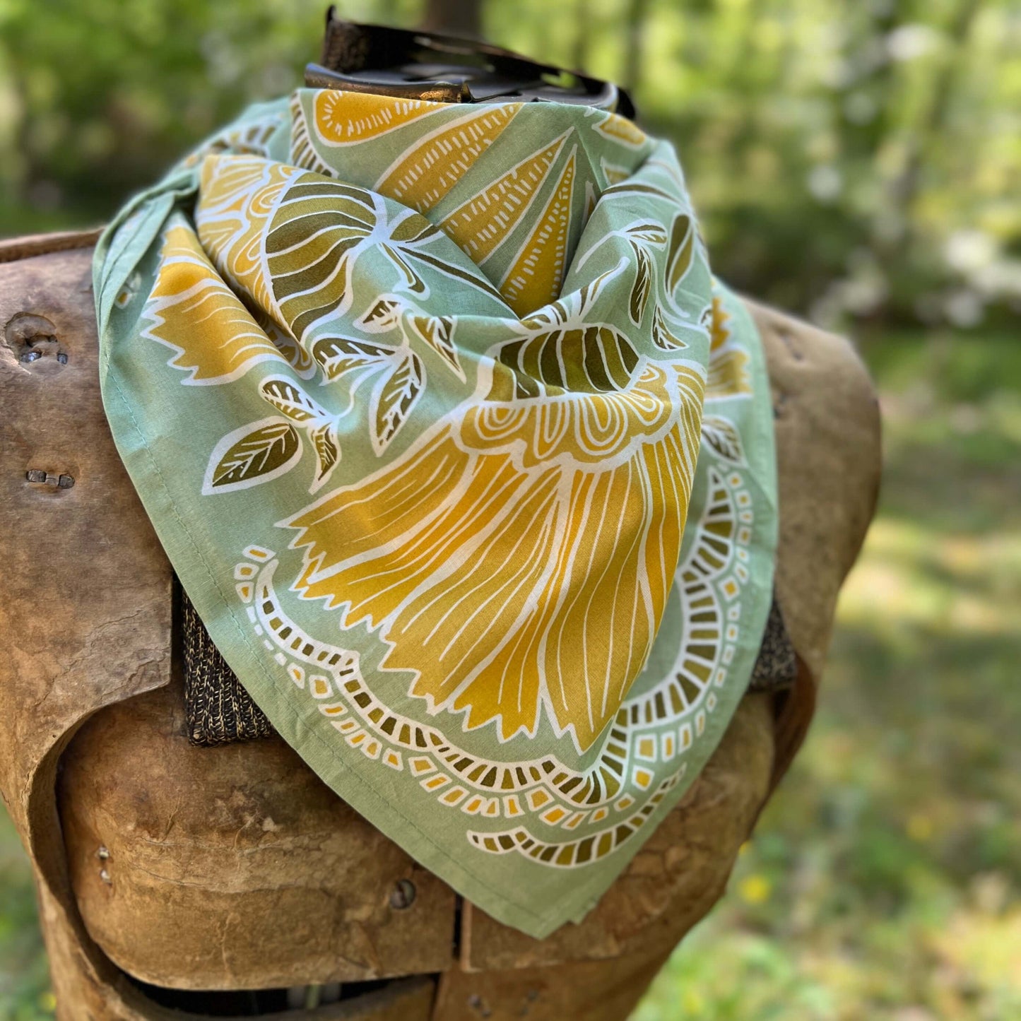 Green and yellow floral bandana with a natural background