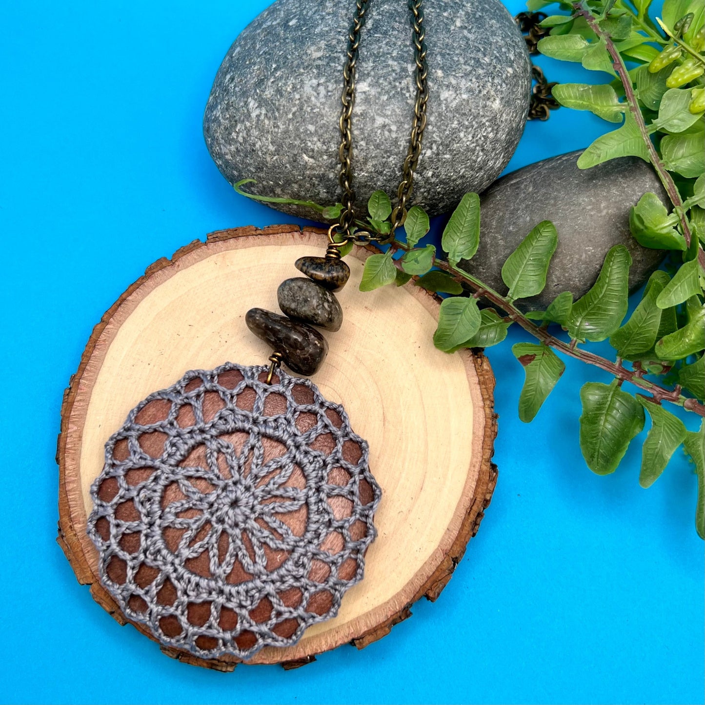 dark gray crocheted mandala pendant on long chain necklace