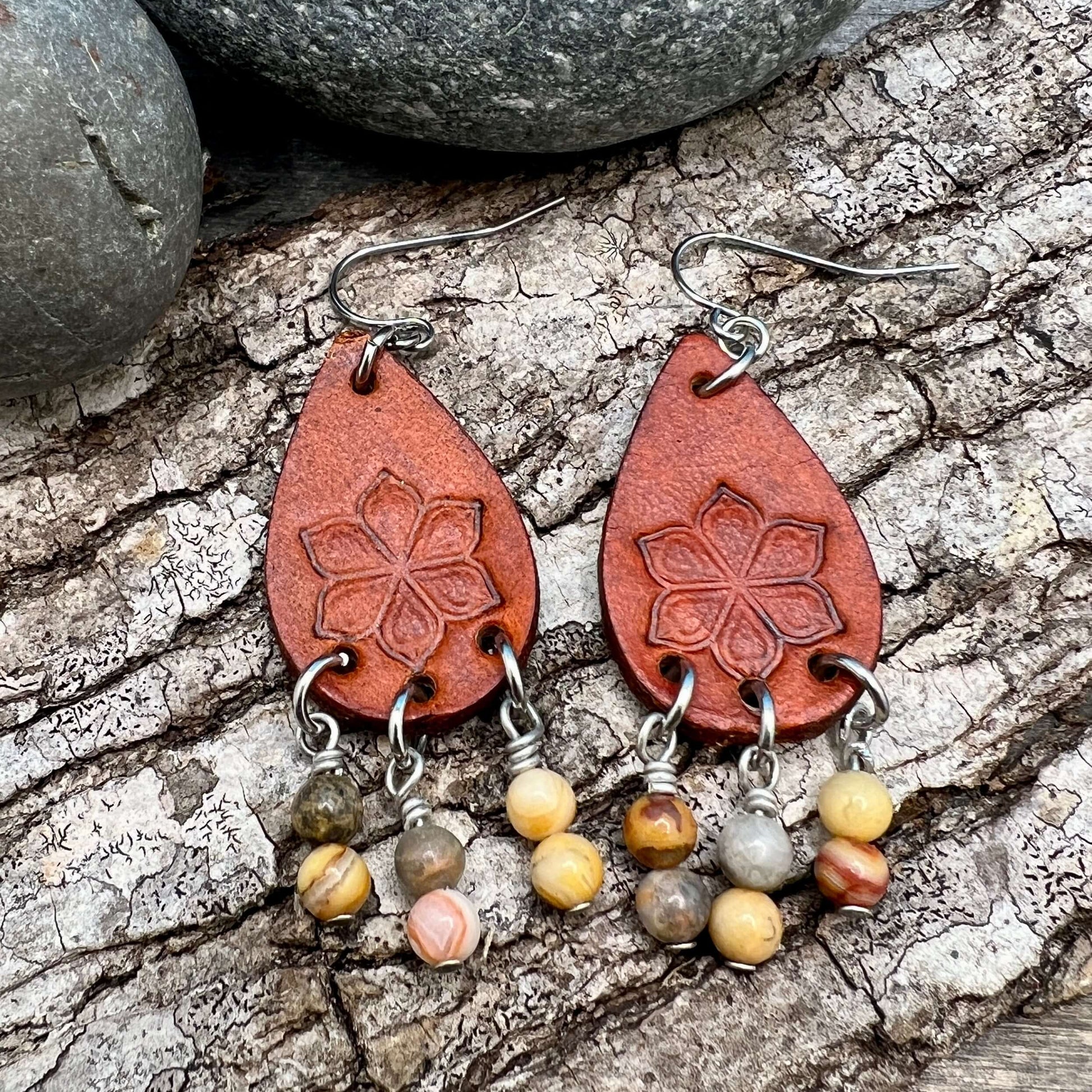 Leather Teardrop Earrings with Natural Stone DanglesLeather teardrop earrings are cut from genuine veg tanned leather, stamped and dyed in a antiqued saddle tan or dark brown. Accented with a trio of natural stone dangles these rustic bohemian style compl