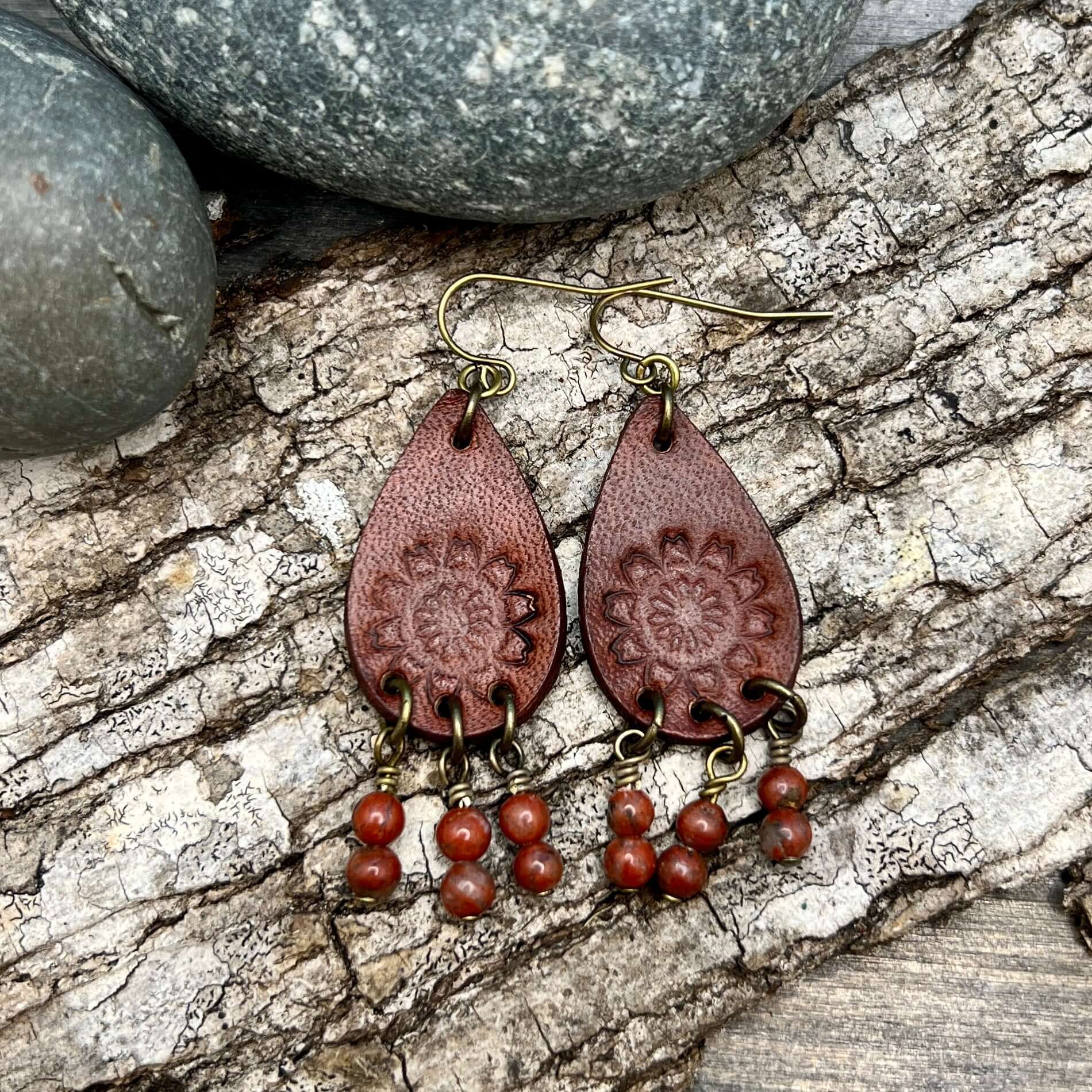 Leather Teardrop Earrings with Natural Stone DanglesLeather teardrop earrings are cut from genuine veg tanned leather, stamped and dyed in a antiqued saddle tan or dark brown. Accented with a trio of natural stone dangles these rustic bohemian style compl