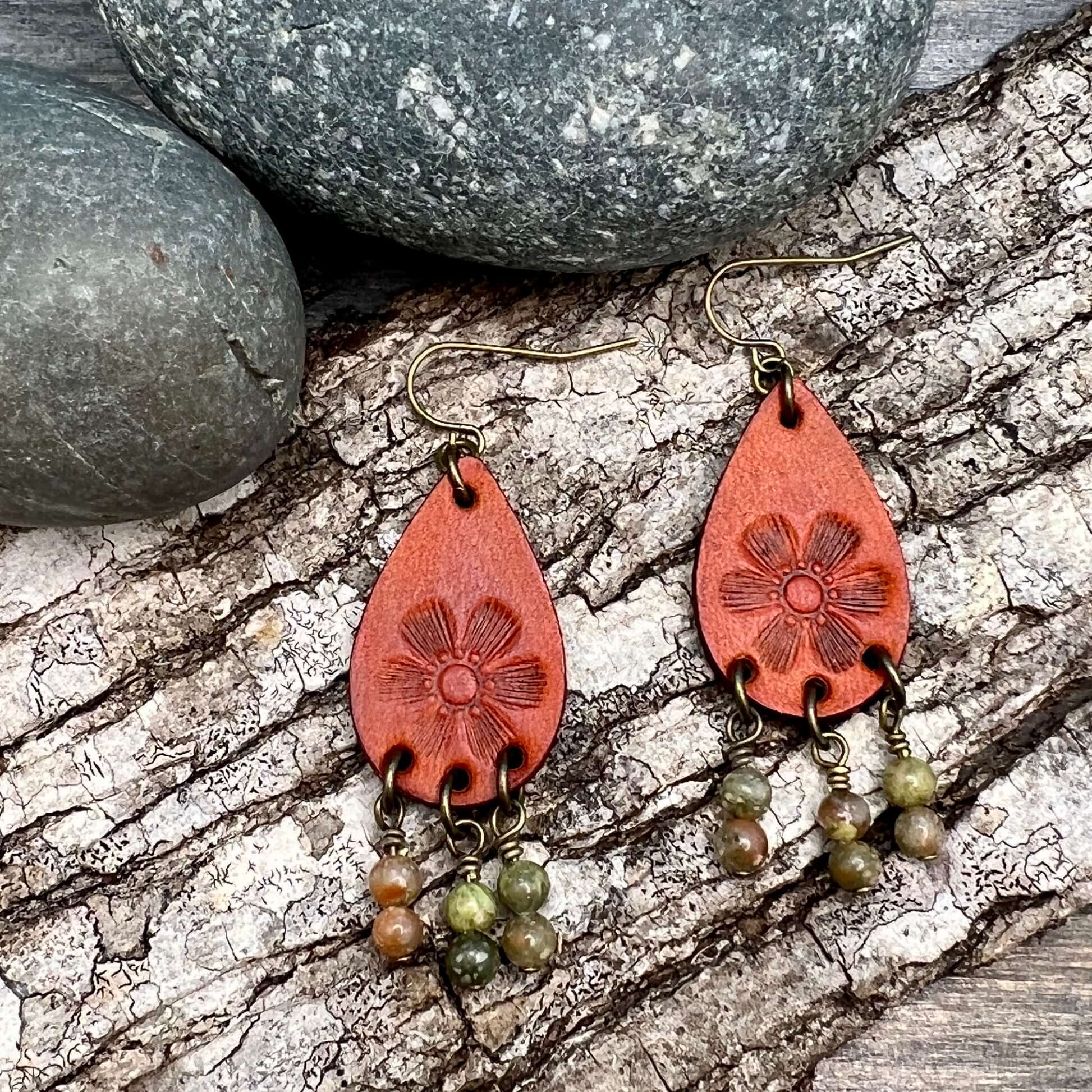 Leather Teardrop Earrings with Natural Stone DanglesLeather teardrop earrings are cut from genuine veg tanned leather, stamped and dyed in a antiqued saddle tan or dark brown. Accented with a trio of natural stone dangles these rustic bohemian style compl