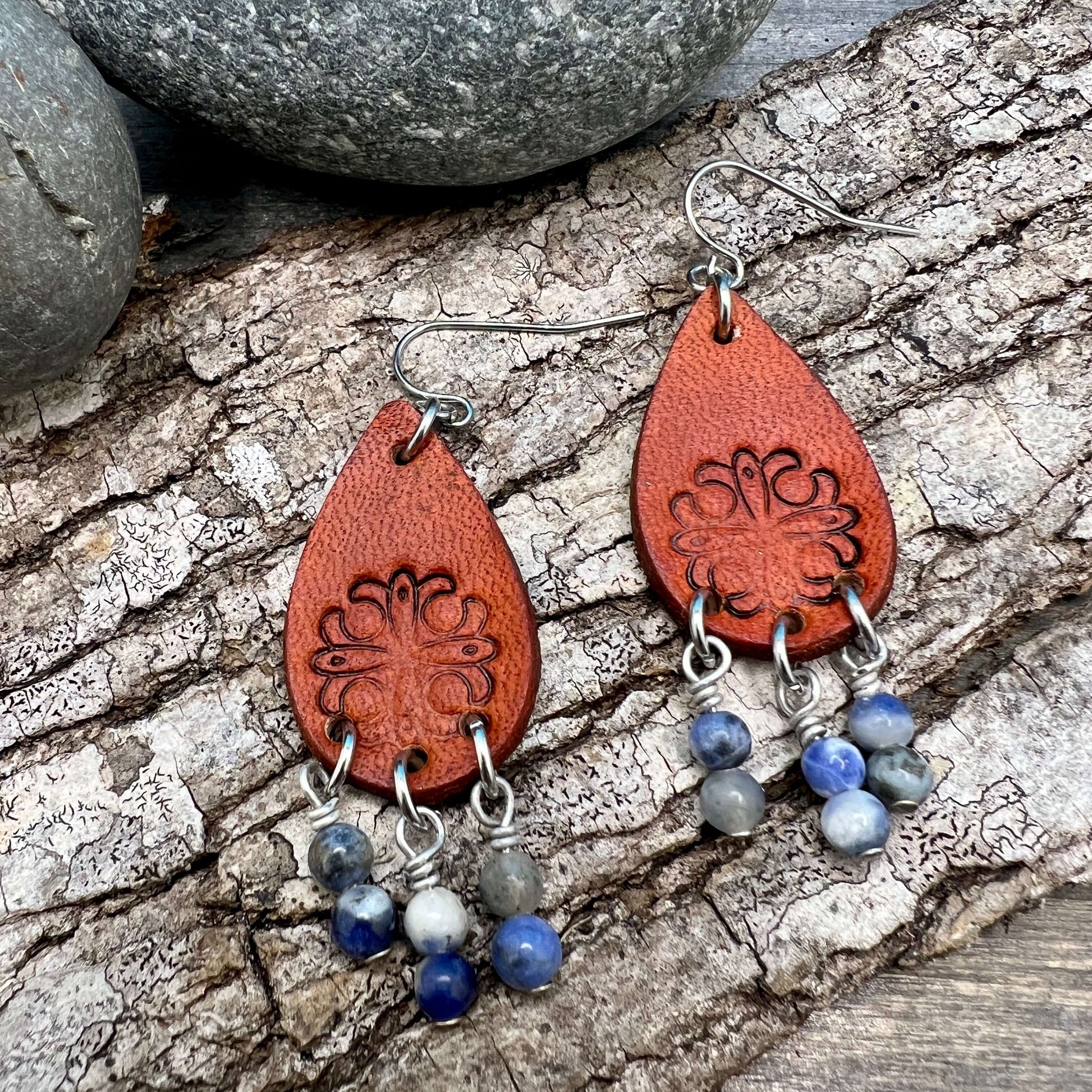 Leather Teardrop Earrings with Natural Stone DanglesLeather teardrop earrings are cut from genuine veg tanned leather, stamped and dyed in a antiqued saddle tan or dark brown. Accented with a trio of natural stone dangles these rustic bohemian style compl