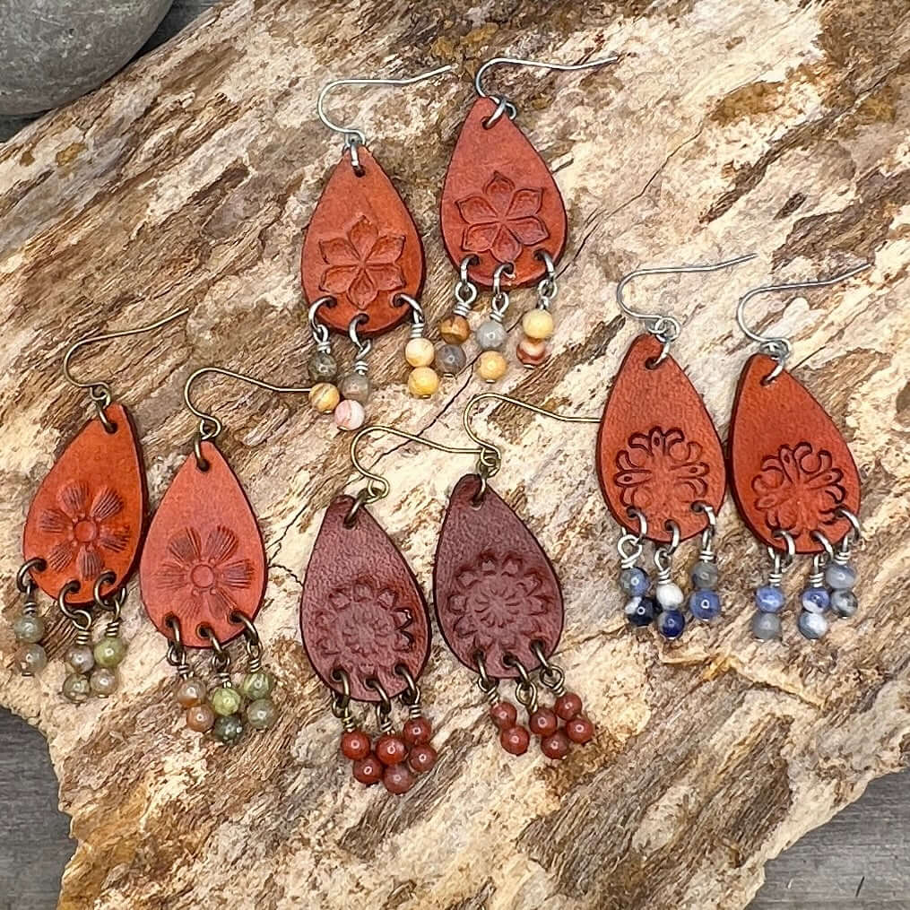 Leather Teardrop Earrings with Natural Stone DanglesLeather teardrop earrings are cut from genuine veg tanned leather, stamped and dyed in a antiqued saddle tan or dark brown. Accented with a trio of natural stone dangles these rustic bohemian style compl