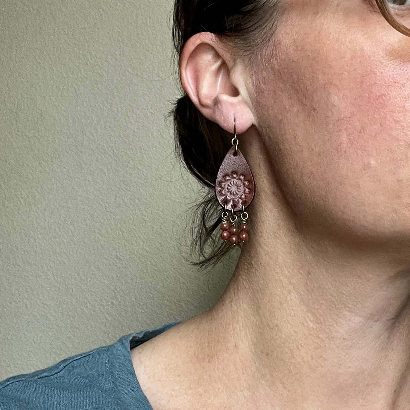 Leather Teardrop Earrings with Natural Stone DanglesLeather teardrop earrings are cut from genuine veg tanned leather, stamped and dyed in a antiqued saddle tan or dark brown. Accented with a trio of natural stone dangles these rustic bohemian style compl