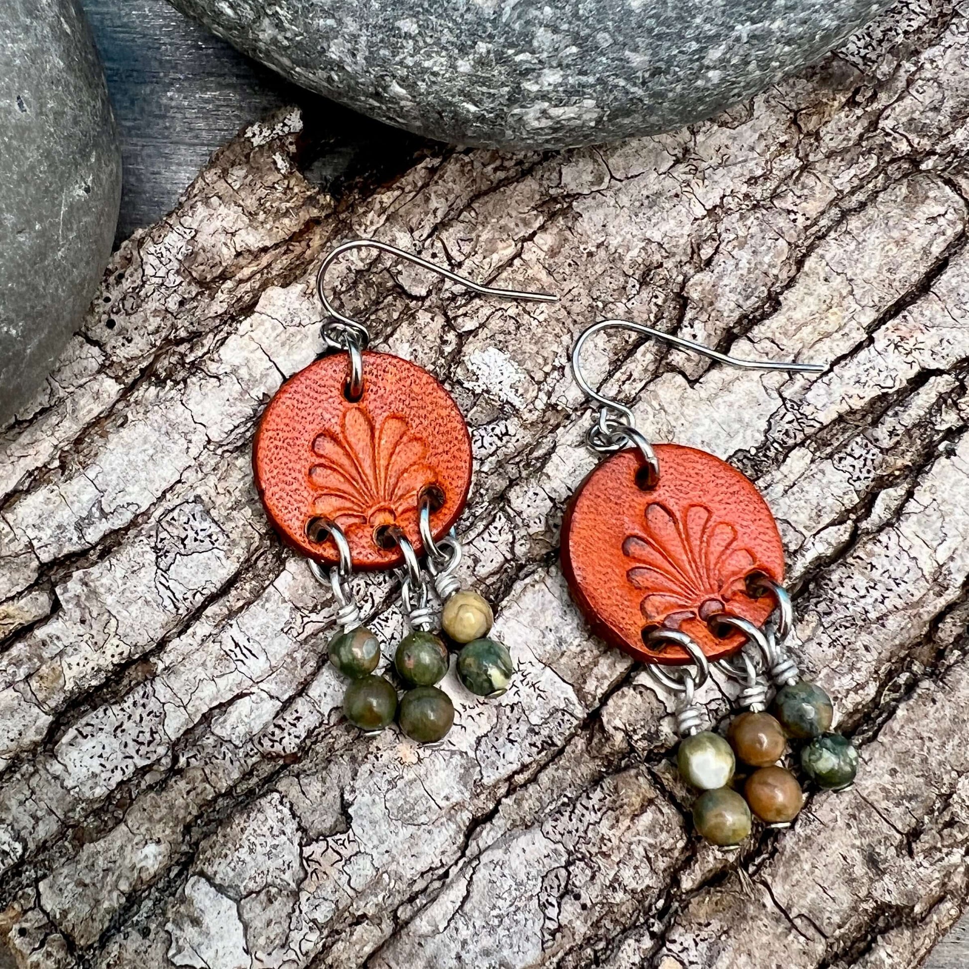 Leather Coin Earrings with Natural Stone DanglesLeather coin earrings are cut from genuine veg tanned leather, stamped and dyed in a antiqued saddle tan or dark brown. Accented with a trio of natural stone dangles these rustic bohemian style compliments a