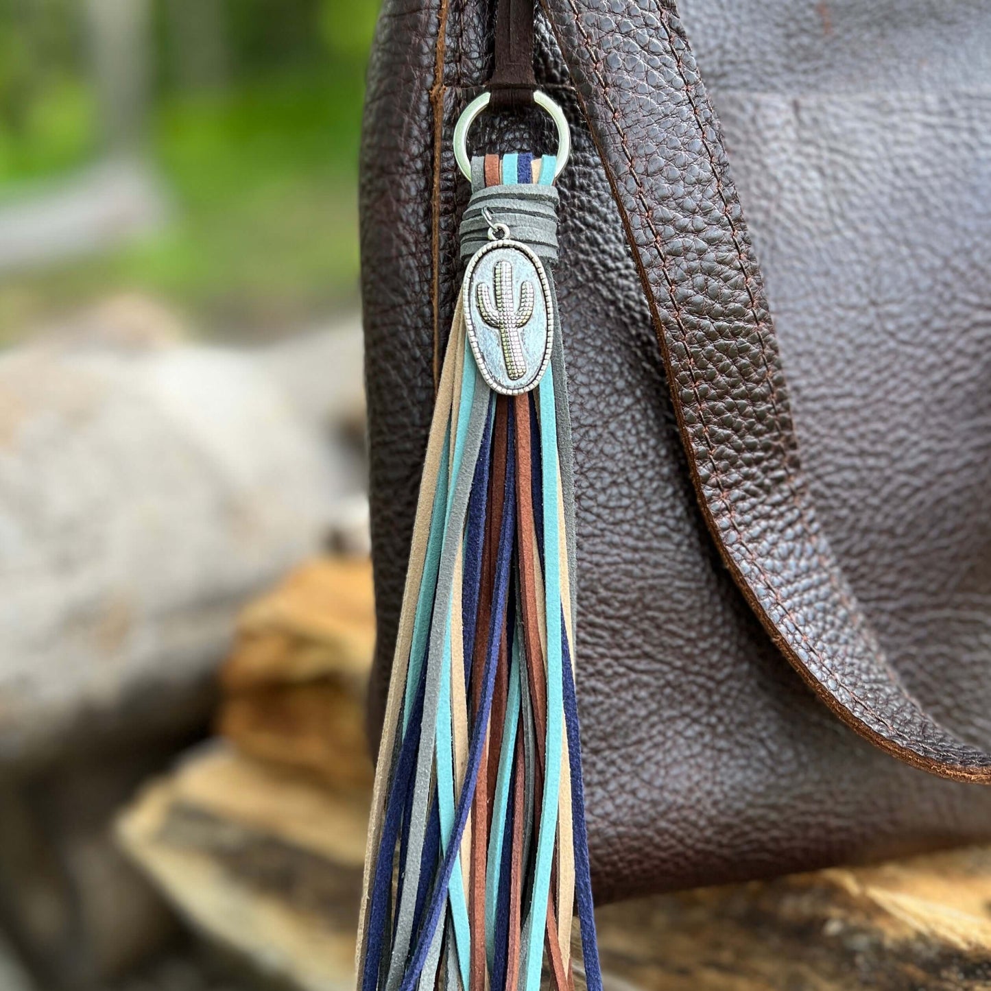 Tassel Purse Charm - Western Style with CactusChic and simple faux suede tassel purse charm with give your tote or bag an instant western vibe. Crafted with earthy colors of faux suede in navy, dusty blue, sand brown, cocoa brown and dark gray and accente