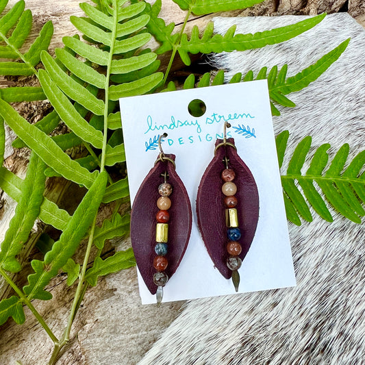 Leather Petal Earrings - Deep Purple with Jasper DanglesAdd a little boho flair to your day with genuine leather earrings. Deep purple leather petal is accented with genuine Jasper and bronze glass bead on antique gold arrowhead pin. Lightweight earrings