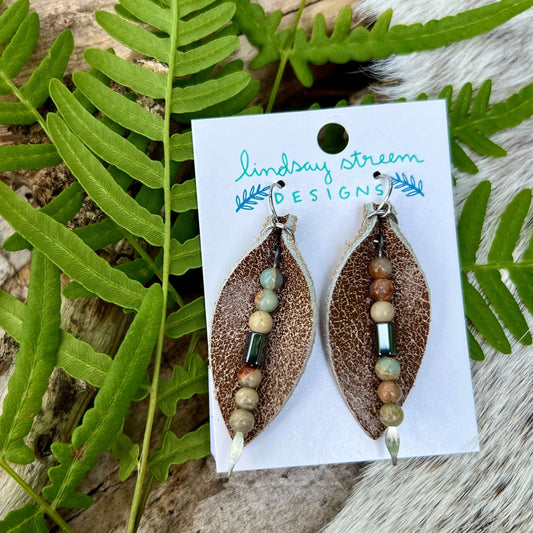 Leather Petal Earrings - Brown with Aqua Terra JasperAdd a little boho flair to your day with genuine leather earrings. distressed brown leather petal is accented with genuine Aqua Terra Jasper and gunmetal glass bead on silver arrowhead pin. Lightweight