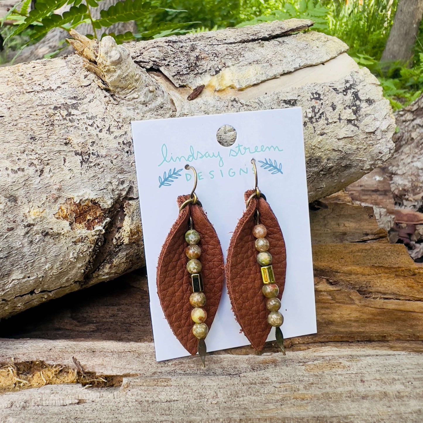 Leather Petal Earrings - Warm Brown with Autumn JasperAdd a little boho flair to your day with genuine leather earrings. Warm brown leather petal is accented with genuine Jasper and bronze glass bead on antique gold arrowhead pin. Lightweight earrings are