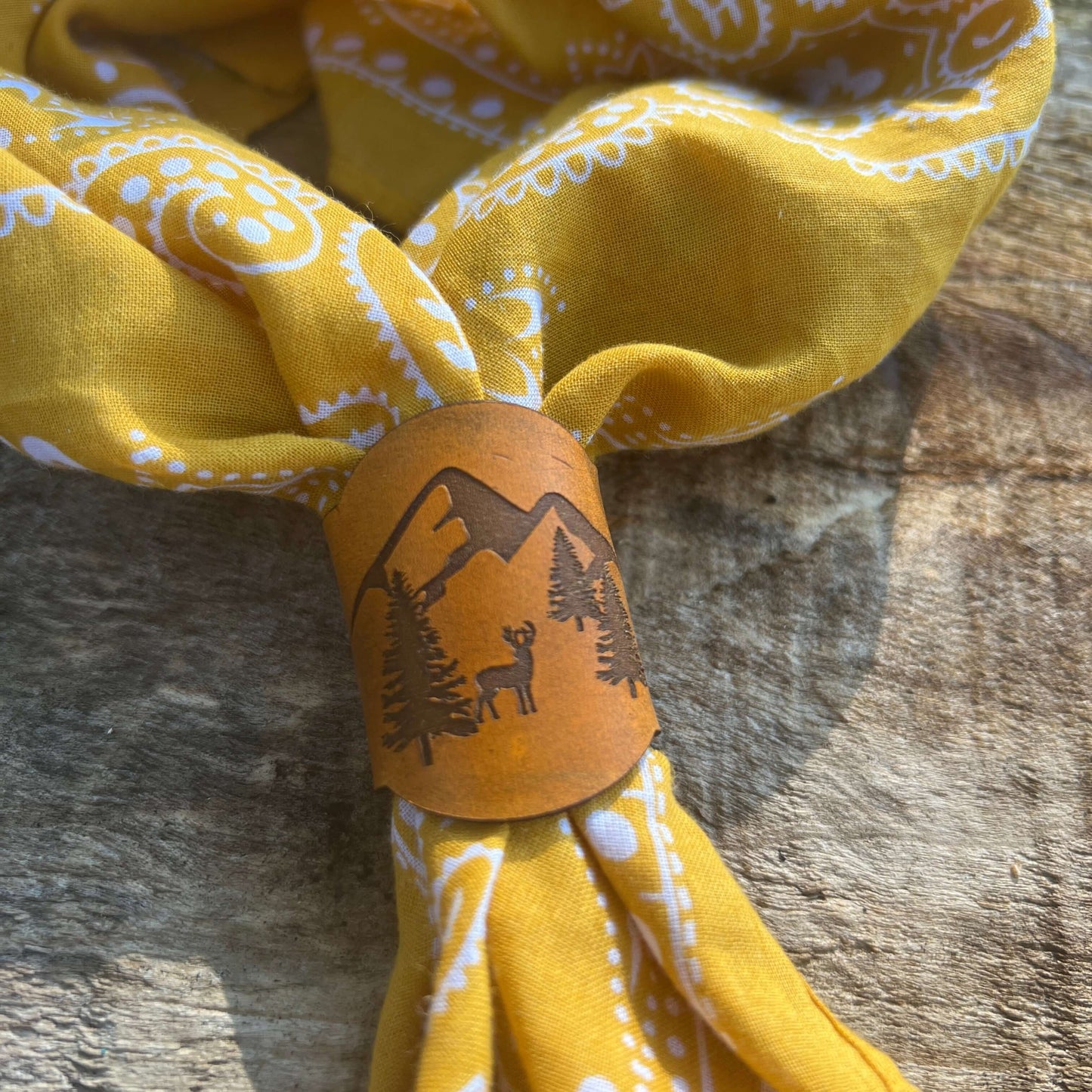 Bandana Slide - Vintage Tan Leather - MountainsSimple and chic leather bandana slide. Classic style snaps on or slides over light weight scarves and bandanas. 3.75" long and 1.75" wide. Snaps at 3" Genuine veg tanned leather laser cut and engraved. Dyed w