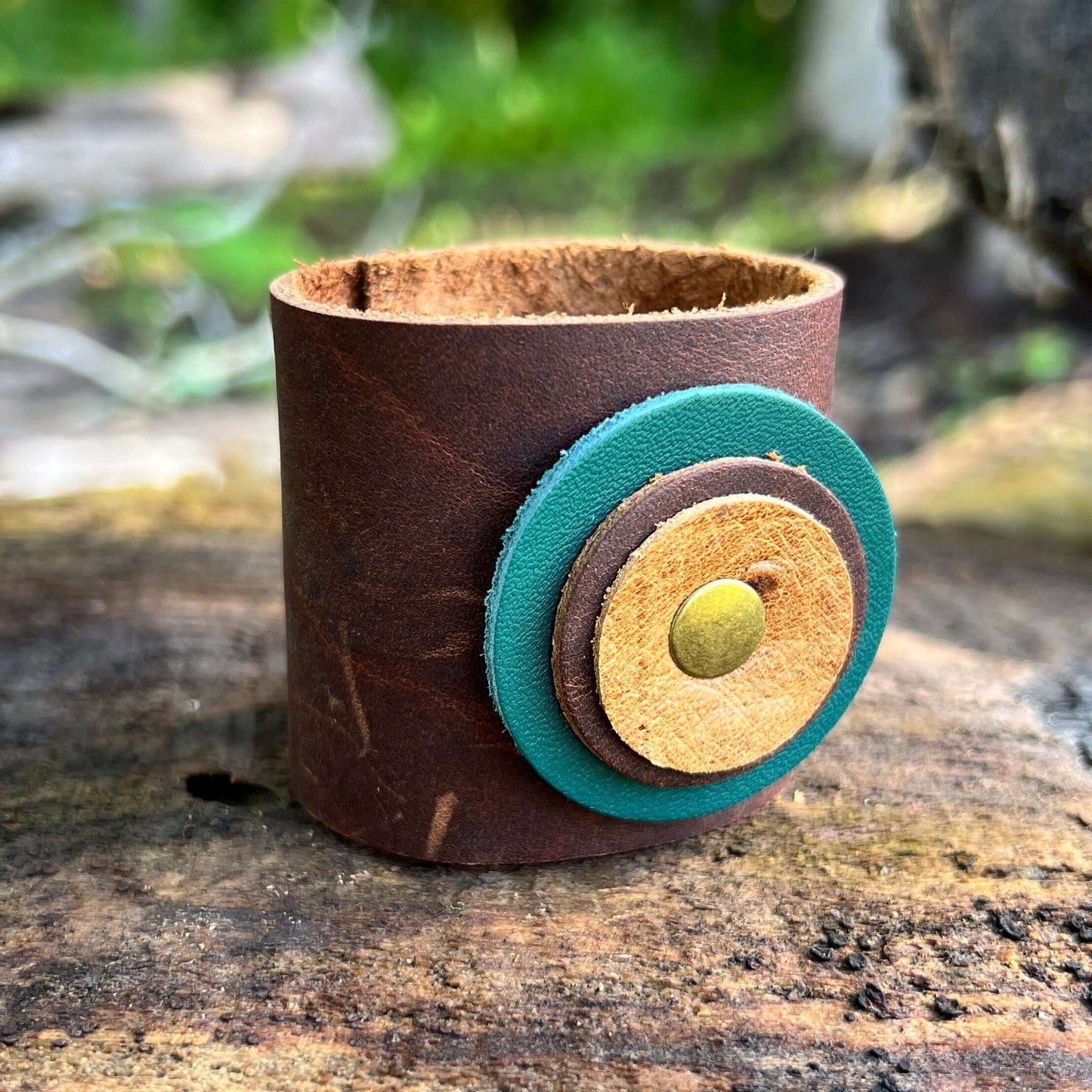 Scarf Cuff for Winter Scarves and Shawls - BrownAccessorize your scarf with a leather scarf cuff. Crafted with genuine leather and accented with a layered leather circle. Double snap closure for a secure wear. 2" wide and snaps closed between 5.5 and 6" F