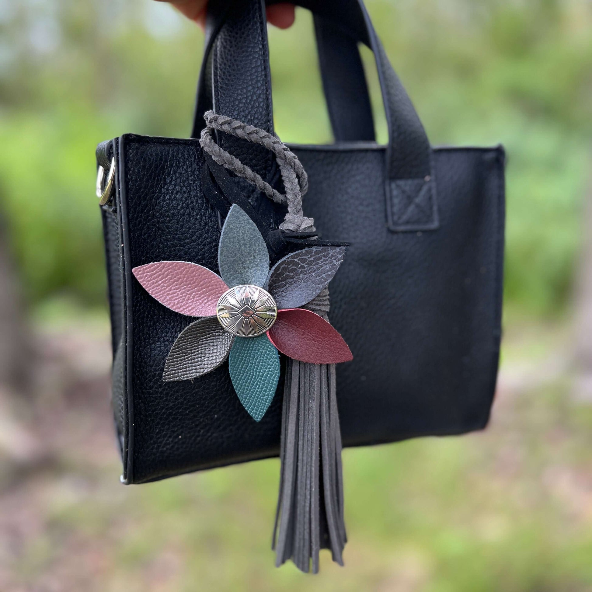 Leather Flower Bag Charm with Tote Loop in Fall Multi ColorBag charms are a great way to update your handbag, purse or tote. Each flower is crafted with leather petals securely sewn and glued together. Silver tone metal button adds a little western flair.