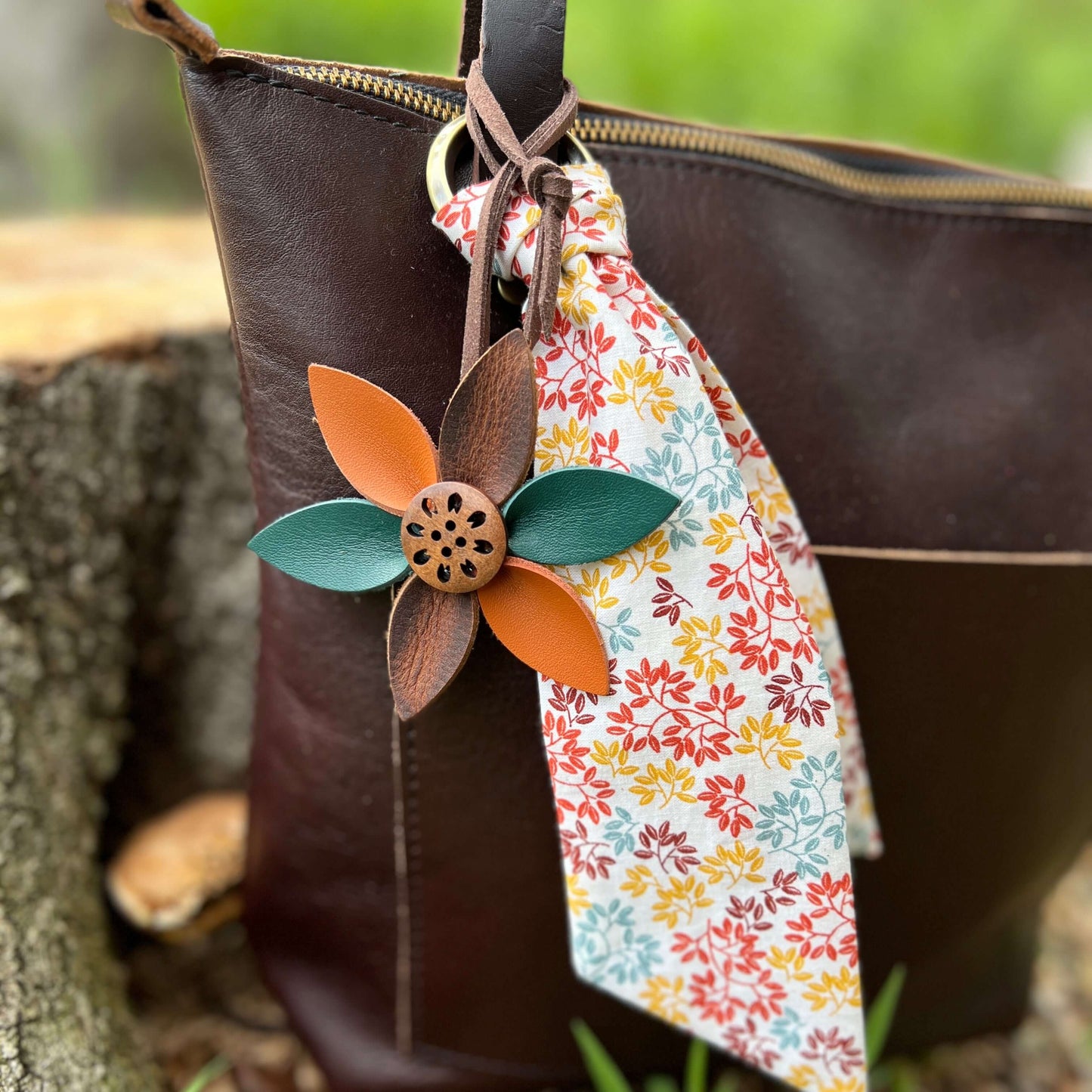 Leather Flower Bag Charm with Tote Loop in Autumn LeavesBag charms are a great way to update your handbag, purse or tote. Each flower is crafted with leather petals securely sewn and glued together. Silver tone metal button adds a little western flair. Fl