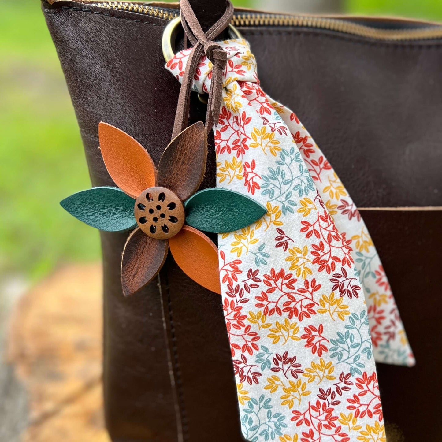 Leather Flower Bag Charm with Tote Loop in Autumn LeavesBag charms are a great way to update your handbag, purse or tote. Each flower is crafted with leather petals securely sewn and glued together. Silver tone metal button adds a little western flair. Fl