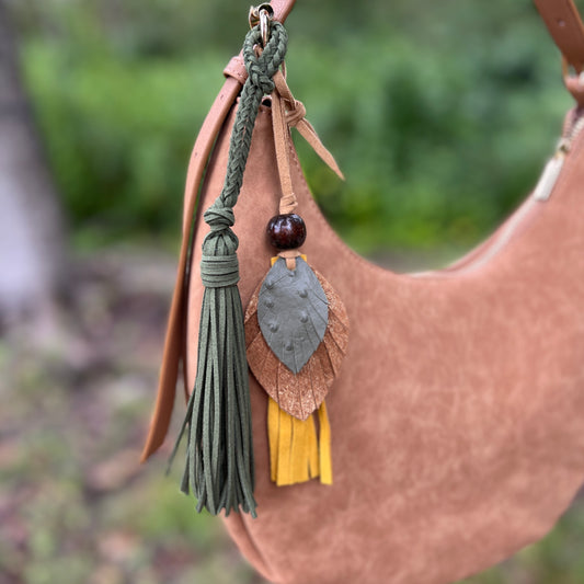 olive green tassel and leather feather bag charm on tan purse