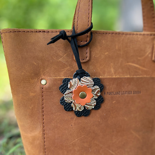 black and orange small leather flower bag charm on tan tote
