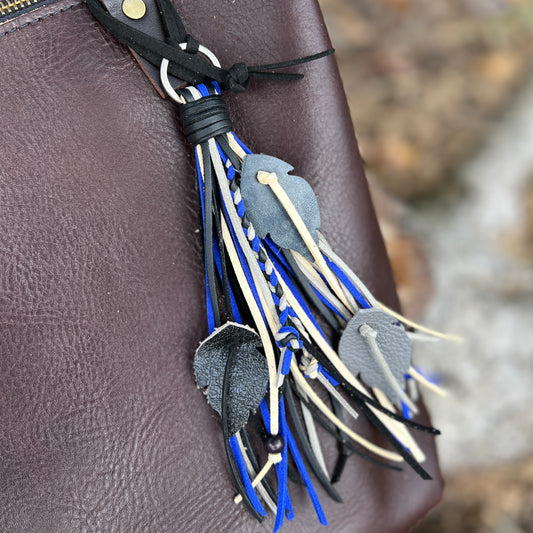 Festival Tassel Purse Charm - SmallWestern style tassel purse charm is crafted with strands of faux suede, leather feathers and wooden beads. One of a kind tassel will give your bag an instant bohemian vibe. 7" fringe tassel on 1" ring with 5" faux suede