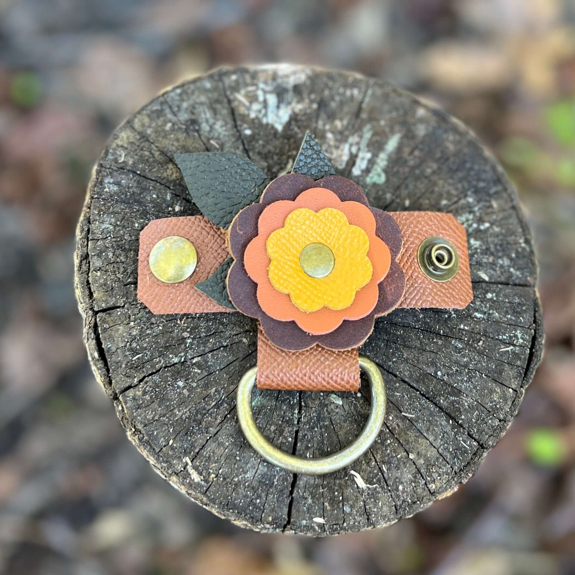 Purse Charm Holder - FlowersNew! keep your bag and purse charms in place with a handy snap on holder. Crafted with sturdy leather and accented with a layered flower, these charm holders will be the best thing you bought all year. Snaps at 2.75" and fits m