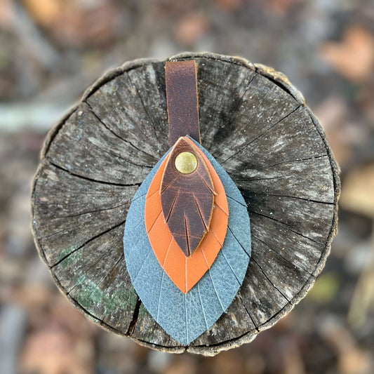 Leather Feather Bag Charm - Brown, Orange and Denim BlueLeather feather charms are the perfect way to add a little flair to your handbag, tote or purse. Handcrafted with layers of genuine leather and securely riveted to a leather loop with your choice of