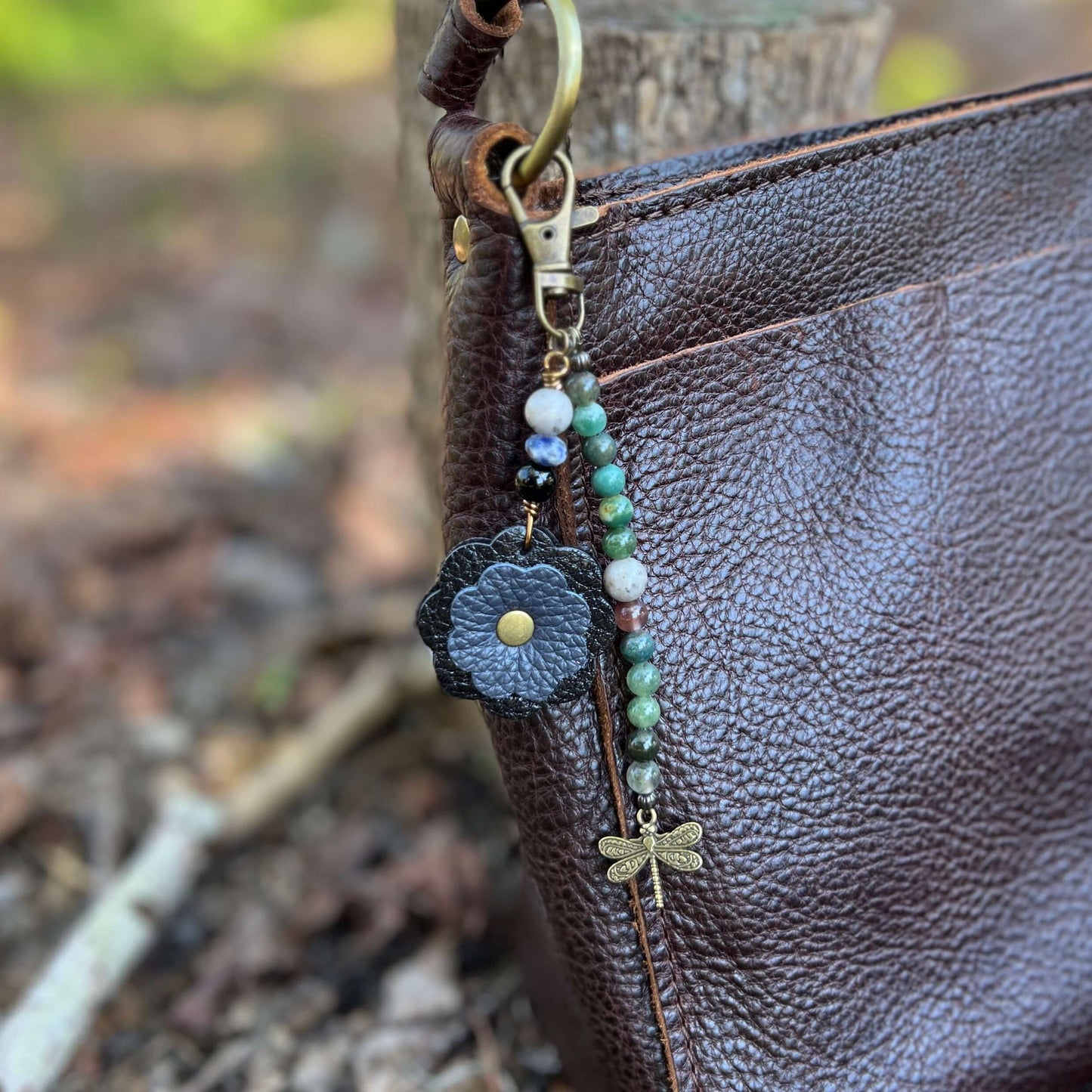 Beaded Bag Charm with Leather FlowerGive your handbag or purse an instant update with a beaded purse charm. Constructed on heavy gauge beading wire with natural stones, bohemian charms and genuine leather flower. - Each charm is between 4.5" length from c