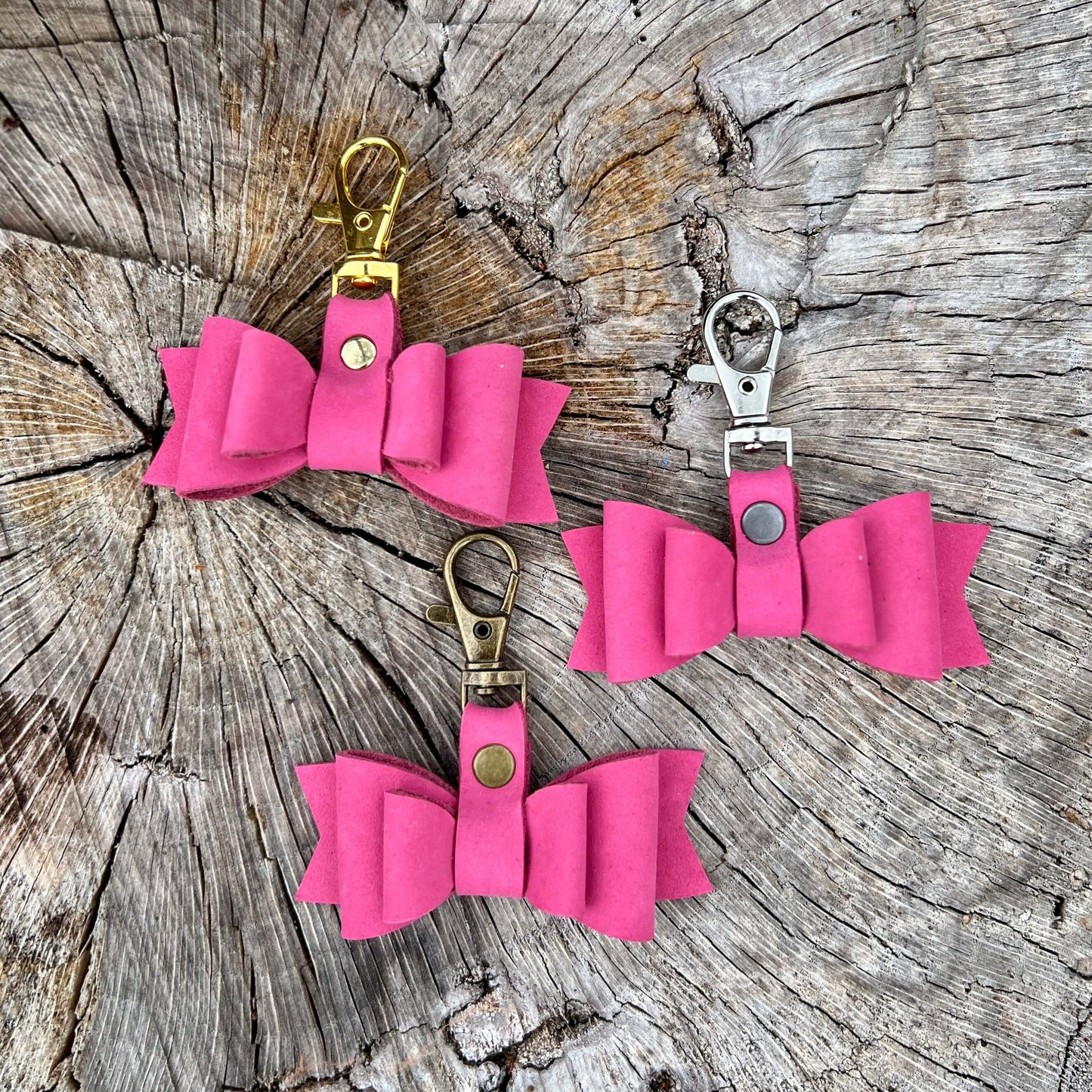 These sweet little leather bows will be the perfect addition to your purse, handbag or tote. Crafted with soft nubuck leather in pink . - Bows are 2.5" wide and 2.75" total length including clip.- Choose your metal finish to match your bag.- Other charms