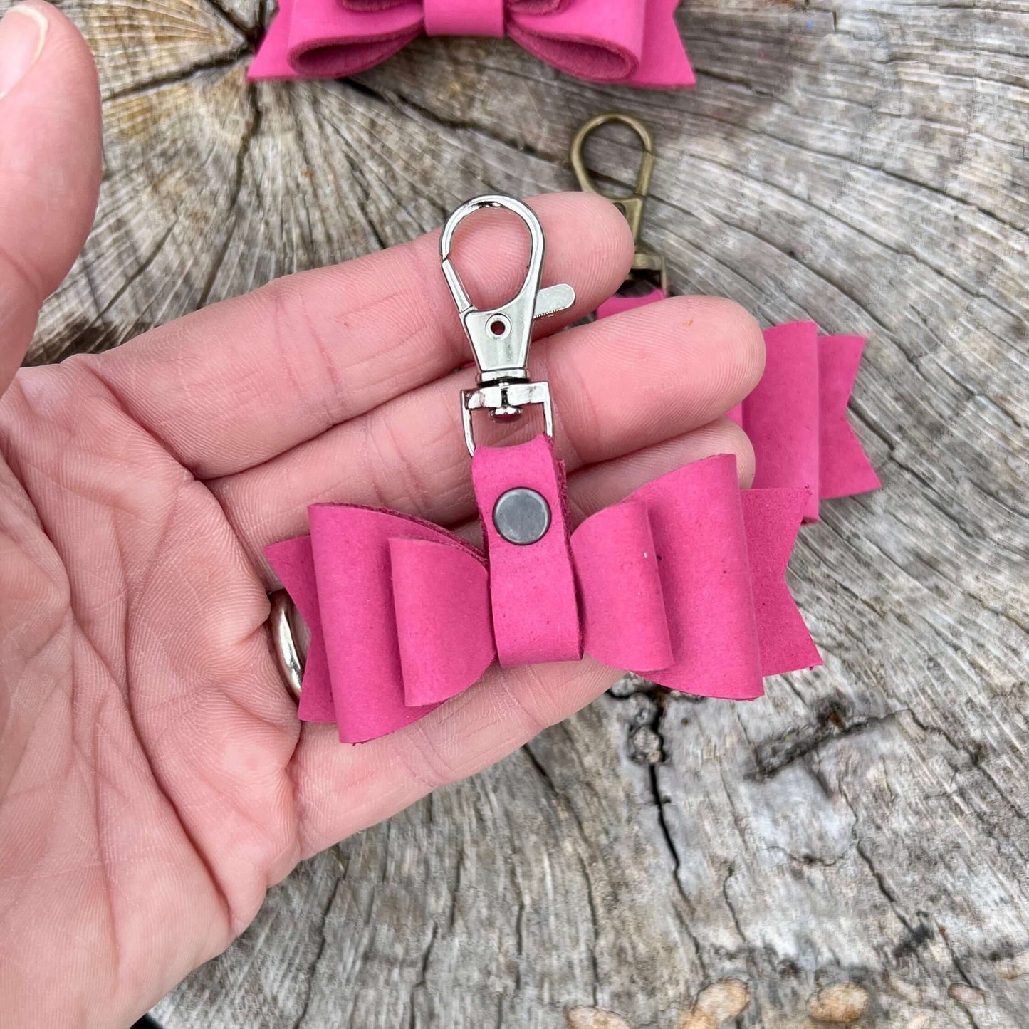 These sweet little leather bows will be the perfect addition to your purse, handbag or tote. Crafted with soft nubuck leather in pink . - Bows are 2.5" wide and 2.75" total length including clip.- Choose your metal finish to match your bag.- Other charms