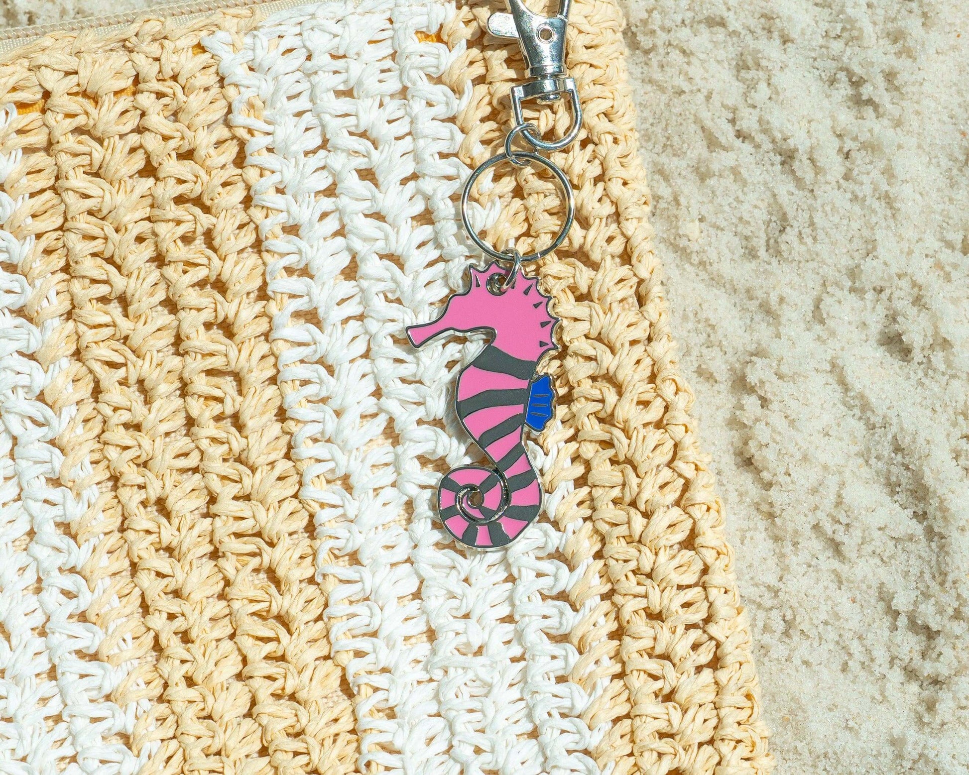 Keychain with a pink seahorse design on a textured surface